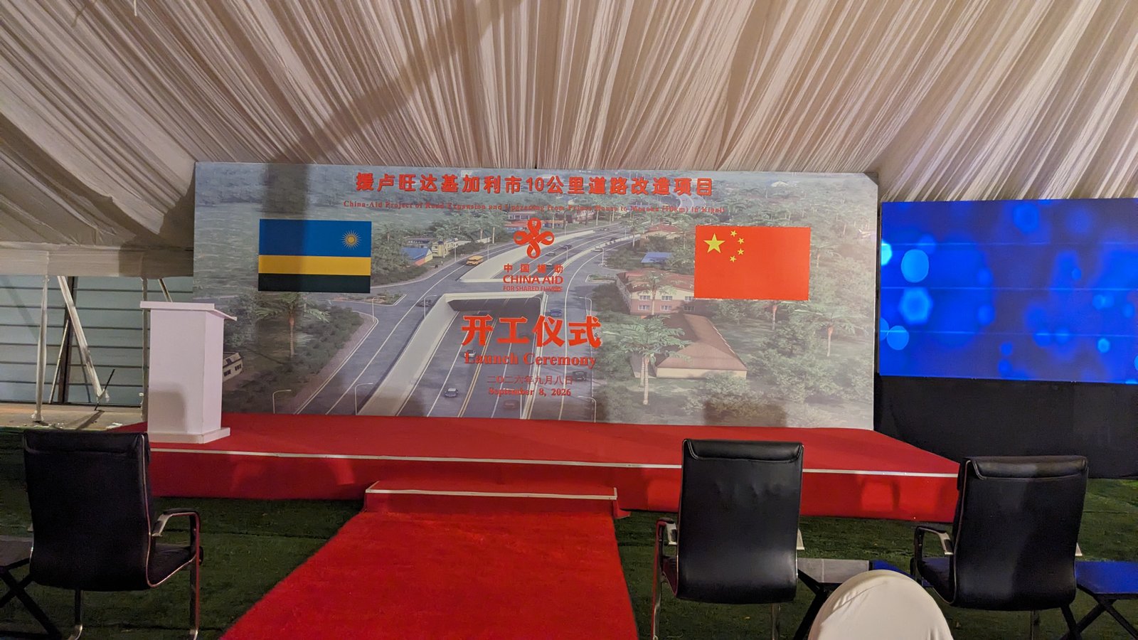Stage backdrop and podium inside tent for launch ceremony in Kigali